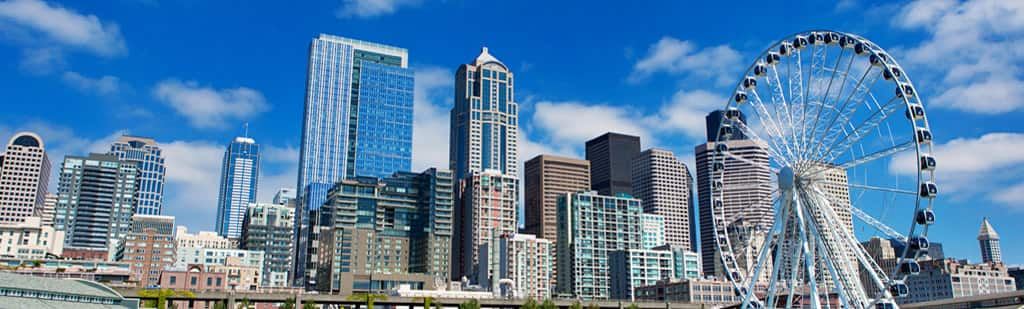 See the day time skyline of  Seattles' Great Wheel in Elliot Bay on an overnight hotel stay with Oceania Cruises.