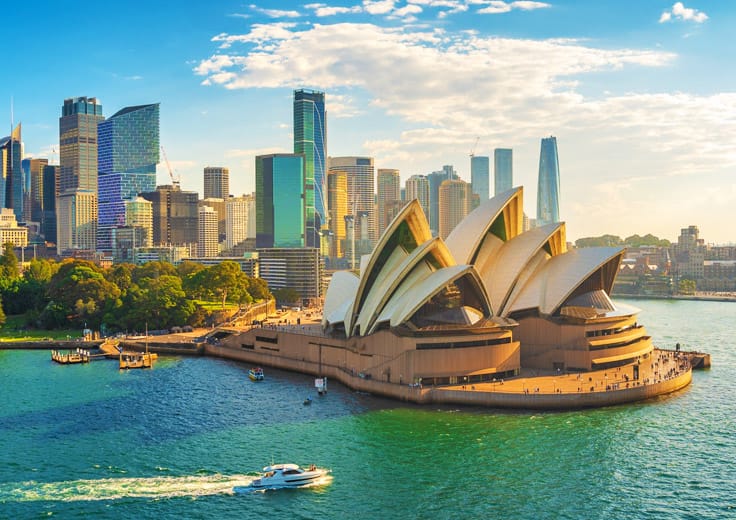 The iconic Sydney Opera House with its distinctive white sail-shaped shells, set against the backdrop of Sydney Harbour.