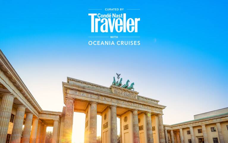 Traditional red-sailed junk boat sailing across Victoria Harbour with the Hong Kong skyline and a golden sunset in the background.